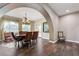 Elegant dining room features wood floors, detailed chandelier, archway and large windows at 8490 Via De Bellasidra Ct, Las Vegas, NV 89123