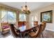 Well-lit dining room with an ornate chandelier and large windows offering beautiful views of backyard at 8490 Via De Bellasidra Ct, Las Vegas, NV 89123