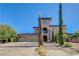 Impressive two-story home with a stone archway, balcony, and lush landscaping at 8490 Via De Bellasidra Ct, Las Vegas, NV 89123