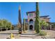 Beautiful two-story home with a stone archway, balcony, and lush landscaping at 8490 Via De Bellasidra Ct, Las Vegas, NV 89123