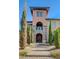 Stunning home with a stone facade, arched entryway, and manicured landscaping at 8490 Via De Bellasidra Ct, Las Vegas, NV 89123