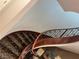 Elegant curved staircase with wood railing and patterned carpet at 8490 Via De Bellasidra Ct, Las Vegas, NV 89123