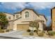 Two-story house with a tan facade and attached garage at 9240 Long Grove Ave, Las Vegas, NV 89149