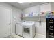 Bright laundry room with washer, dryer, and ample storage shelving at 9240 Long Grove Ave, Las Vegas, NV 89149