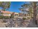 View of backyard with mature trees and gravel at 10009 Hemet Dr, Las Vegas, NV 89134