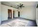 Bright bedroom features a ceiling fan, large window, and grey carpet at 10009 Hemet Dr, Las Vegas, NV 89134