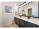 Double vanity bathroom with dark cabinets, gold accents, and a large mirror at 10134 Donald Weese Ct, Las Vegas, NV 89129