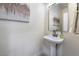 Small powder room with pedestal sink, black fixtures, and art at 10134 Donald Weese Ct, Las Vegas, NV 89129