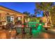 Outdoor kitchen, dining area, fire pit, and lush landscaping at 10414 Hemingway Ct, Las Vegas, NV 89149