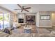 Bright and airy living room with a stone fireplace and large TV at 10414 Hemingway Ct, Las Vegas, NV 89149