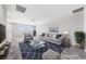 Virtually staged bonus room with gray sofa and blue accents at 1070 Kelly Brook Ln, Henderson, NV 89011