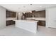 Modern kitchen with large island, dark cabinets, and stainless steel appliances at 1070 Kelly Brook Ln, Henderson, NV 89011