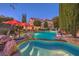 Beautiful backyard pool and mature trees, with a cozy seating area under vibrant red umbrellas, perfect for relaxation at 1705 Corta Bella Dr, Las Vegas, NV 89134