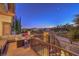 A relaxing balcony showcases cozy outdoor furniture and a scenic view of the evening skyline at 1705 Corta Bella Dr, Las Vegas, NV 89134