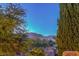 Landscaped view features trees and mountain backdrop at 1705 Corta Bella Dr, Las Vegas, NV 89134