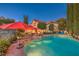 Relaxing pool area with red umbrellas and patio furniture at 1705 Corta Bella Dr, Las Vegas, NV 89134