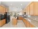 Open kitchen with granite countertops, island, and stainless steel appliances at 2000 Poppywood Ave, Henderson, NV 89012