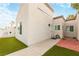 Exterior view of a light-colored stucco house with a small front yard and walkway at 2254 High Dunes Ln, Laughlin, NV 89029