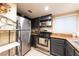 View of a kitchen with dark cabinets, stainless steel appliances, and granite countertops at 2254 High Dunes Ln, Laughlin, NV 89029