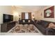 Living room with two brown sofas, a floral rug, and a large flat-screen TV at 2254 High Dunes Ln, Laughlin, NV 89029