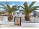 White single story home with palm trees and iron gate at 2824 Bassler St, North Las Vegas, NV 89030