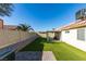 Artificial turf backyard with covered patio and play structure at 3123 Logan Ave, North Las Vegas, NV 89032