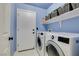 Laundry room with washer, dryer, and storage shelves at 3123 Logan Ave, North Las Vegas, NV 89032