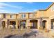 Tan two-story townhome with stone accents, landscaping, and a paved walkway at 3296 Palindrome Ave, Henderson, NV 89044