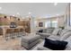 Open concept kitchen and living room with island, stainless steel appliances, and gray sectional sofa at 3296 Palindrome Ave, Henderson, NV 89044