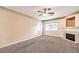 Living room with fireplace, ceiling fan, and neutral carpeting at 3320 S Fort Apache Rd # 125, Las Vegas, NV 89117