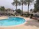 Community pool with lounge chairs and palm trees at 3425 E Russell Rd # 265, Las Vegas, NV 89120