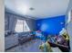 Brightly painted bedroom with a blue accent wall, carpet, and a window with curtains at 433 Jubilation Dr, Las Vegas, NV 89145