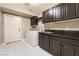 Laundry room with washer, dryer, and dark wood cabinets at 478 Spanish View Ln, Las Vegas, NV 89110