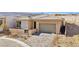 Modern home's exterior with a two-car garage and landscaped front yard at 4973 Sandline Ct, Las Vegas, NV 89135