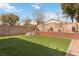 A large, well-manicured backyard featuring artificial turf and a decorative brick retaining wall at 5028 Frozen Springs Ct, Las Vegas, NV 89130