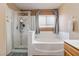 Modern bathroom featuring a glass-enclosed shower, soaking tub, and neutral decor at 5028 Frozen Springs Ct, Las Vegas, NV 89130