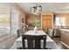 Dining room with table, modern light fixture, wood floors, and natural light from the window at 5028 Frozen Springs Ct, Las Vegas, NV 89130