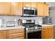 Kitchen featuring oak cabinets, stainless steel microwave and range, with matching appliances at 5028 Frozen Springs Ct, Las Vegas, NV 89130