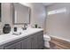 Modern bathroom with gray vanity, white countertop, and black fixtures at 5992 Genovese Ave, Las Vegas, NV 89141