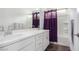 Bathroom with double sinks, purple shower curtain and bathtub at 6075 Wyndham Estate Ave, Las Vegas, NV 89141