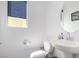 Well-lit powder room featuring modern fixtures and a sleek round mirror above the sink at 6075 Wyndham Estate Ave, Las Vegas, NV 89141