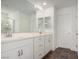 A well-lit Primary bathroom with dual sinks, white cabinetry, and modern fixtures at 6075 Wyndham Estate Ave, Las Vegas, NV 89141