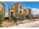 Two-story modern home with green garage door and light brown exterior at 6075 Wyndham Estate Ave, Las Vegas, NV 89141