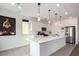 Modern kitchen with white cabinets, quartz countertops, and stainless steel appliances at 6075 Wyndham Estate Ave, Las Vegas, NV 89141