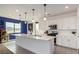 Bright kitchen with large island, white cabinets, stainless steel appliances, and modern pendant lighting at 6075 Wyndham Estate Ave, Las Vegas, NV 89141