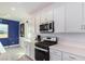 Modern kitchen with white cabinets, stainless steel appliances, and quartz countertops at 6075 Wyndham Estate Ave, Las Vegas, NV 89141