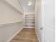 Walk in closet features built-in shelving for maximizing storage and wood-look flooring adding a touch of style at 6178 Pisan Ln, Las Vegas, NV 89148