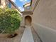 A welcoming front entrance features a curved archway, neutral stucco, and a well-maintained desert landscape at 6178 Pisan Ln, Las Vegas, NV 89148