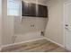 Laundry room with overhead cabinets and utility connections in neutral tones at 6178 Pisan Ln, Las Vegas, NV 89148