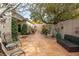 Landscaped backyard oasis with tiled patio, mature trees, and pathways at 6422 Hughes Springs Dr, Las Vegas, NV 89131